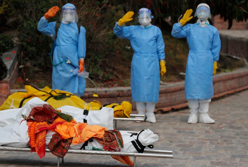 Nhân viên lò thiêu chào vĩnh biệt những người xấu số trước khi đưa họ đi thiêu (Ảnh: AP).