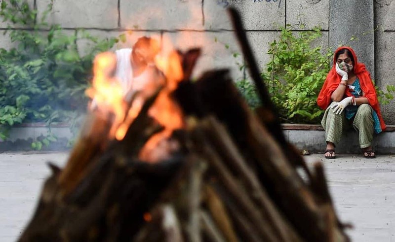 Thân nhân người quá cố ngồi vĩnh biệt người thân trước giàn thiêu (Ảnh: Đa Chiều).