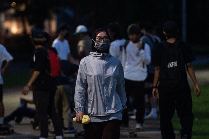 Trong ảnh: một người phụ nữ đeo khẩu trang đi ngoài đường ở Tangerang, ngày 21/6. (Tân Hoa xã) Trong ảnh: một người phụ nữ đeo khẩu trang đi ngoài đường ở Tangerang, ngày 21/6. (Tân Hoa xã)