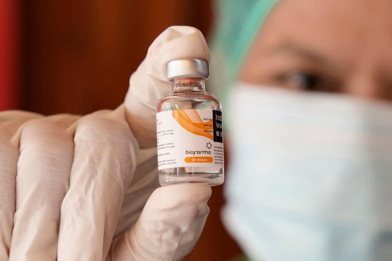 Một nhân viên y tế cầm một lọ vaccine Sinopharm của Trung Quốc do công ty dược phẩm Bio Farma của Indonesia sản xuất được dùng trong đợt tiêm chủng hàng loạt ở Jakarta, ngày 21/6. (AP) Một nhân viên y tế cầm một lọ vaccine Sinopharm của Trung Quốc do công ty dược phẩm Bio Farma của Indonesia sản xuất được dùng trong đợt tiêm chủng hàng loạt ở Jakarta, ngày 21/6. (AP)