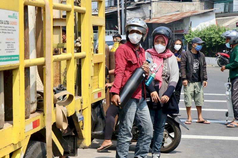 Người dân mang bình đi mua oxy để người thân tự điều trị ở nhà do không có giường trong bệnh viện (Ảnh: CNA). Người dân mang bình đi mua oxy để người thân tự điều trị ở nhà do không có giường trong bệnh viện (Ảnh: CNA).