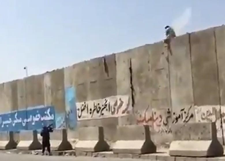 Lính Taliban nhằm bắn một người dân leo tường vào sân bay (Ảnh: Đông Phương). Lính Taliban nhằm bắn một người dân leo tường vào sân bay (Ảnh: Đông Phương).