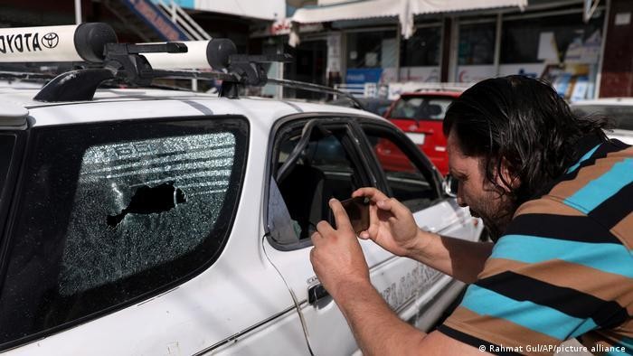 Ngày 6/8/2021, tại Kabul, một nhà báo đang chụp ảnh chiếc xe sau khi Menapar, Giám đốc Trung tâm Thông tin và Truyền thông của Chính phủ Afghanistan, bị Taliban bắn chết (Ảnh: Deutsche Welle).