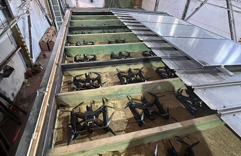Các máy bay không người lái được để trong các khay gỗ giấu trong khoang kín áp mái thùng xe tải. Ảnh: Defenceblog. May bay dua vao.png