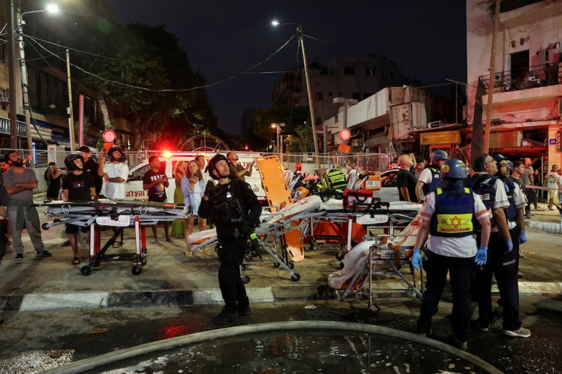 Hình ảnh các nhân viên cứu hộ ở Tel Aviv quan sát tên lửa đang tiếp tục bắn tới. Ảnh: Reuters. Nhan vien cap cuu nhin ten lua.png