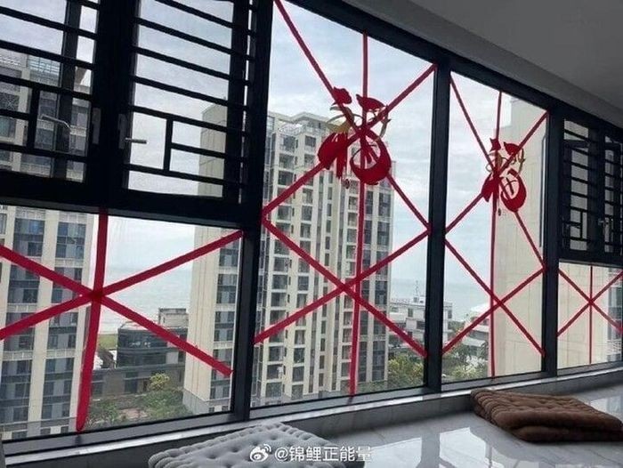 Người dân dùng băng dính chăng chằng chịt để tránh kính bị gió làm đổ vỡ (Ảnh: Weibo). 036a3e3870779929c066.jpg