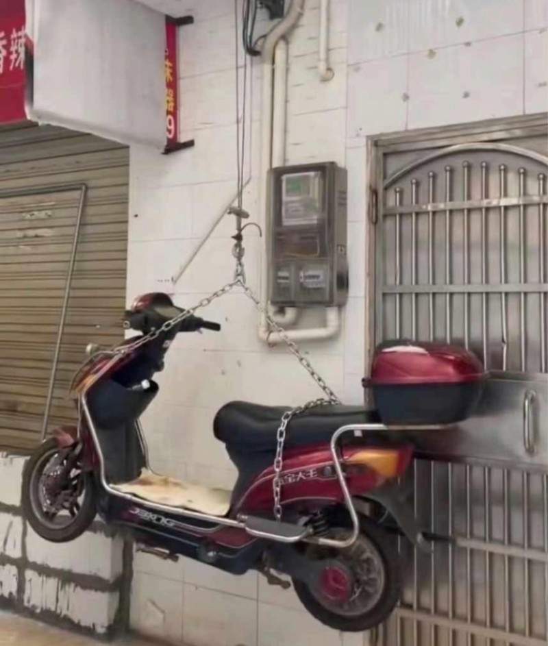 Xe máy được treo bằng xích sắt trên cao để không bị bay đi mất (Ảnh: Weibo). IMG_1423.PNG