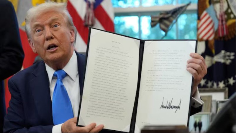 Tổng thống Hoa Kỳ Donald Trump trưng bày sắc lệnh hành pháp đã ký . Ảnh: Reuters. Capture.PNG