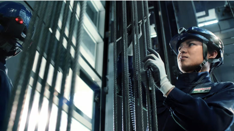 Một kỹ thuật viên của Hitachi Building Systems đang kiểm tra thang máy. Ảnh: Nikkei Asia Ảnh màn hình 2025-10-09 lúc 10.34.05.png