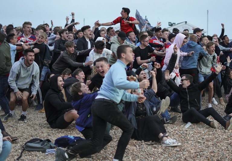 Nhóm cổ động viên tập trung tại bãi biển Brighton để theo dõi trận đấu qua màn hình lớn. Ảnh: Metro Nhóm cổ động viên tập trung tại bãi biển Brighton để theo dõi trận đấu qua màn hình lớn. Ảnh: Metro