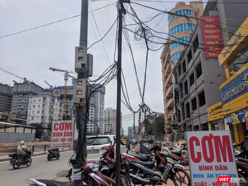 Dây điện, cáp viễn thông bó thành búi trước các cửa hàng.