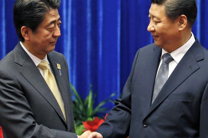 Thủ tướng Nhật Bản Shinzo Abe bắt tay Chủ tịch Trung Quốc Tập Cận Bình tại diễn đàn APEC tổ chức ở Bắc Kinh. Ảnh: AP