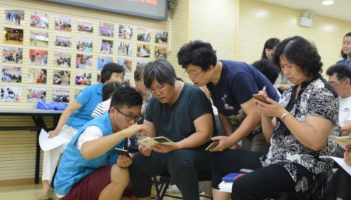 Người già Trung Quốc học cách dùng smartphone ảnh 1 Tình nguyện viên đang dạy một nhóm phụ nữ lớn tuổi các bước để sử dụng điện thoại.