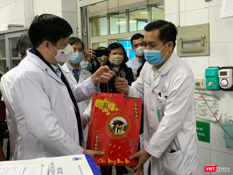 Bộ trưởng Bộ Y tế Nguyễn Thanh Long (trái) tặng quà các thầy thuốc trong kíp trực ngày 30 tết ở BV Việt Đức