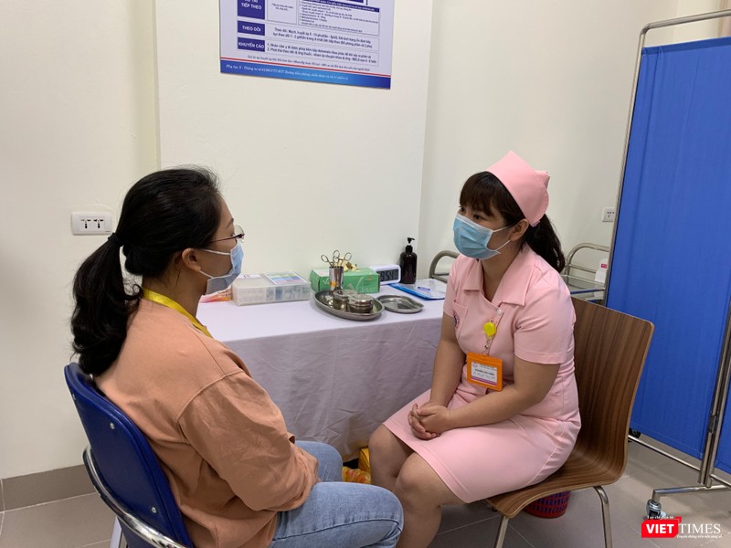 Nhân viên y tế trò chuyện với người tình nguyện trước khi tiêm