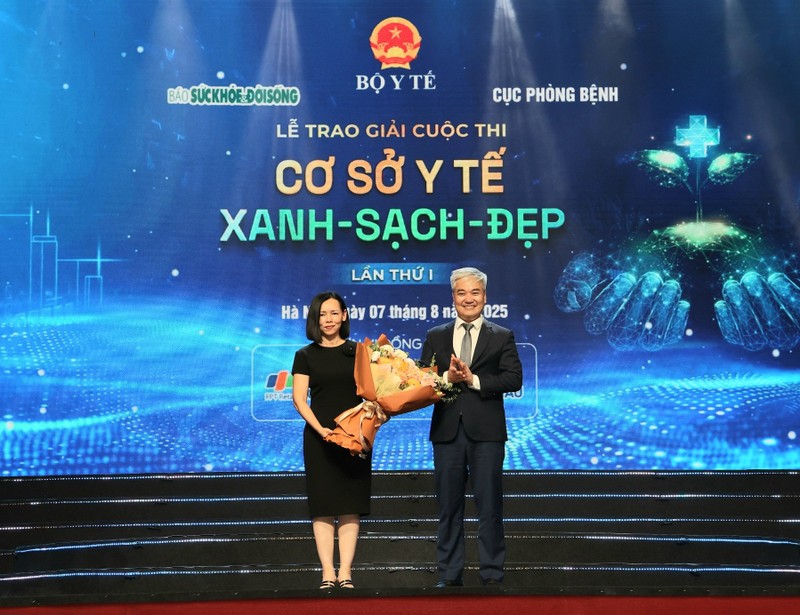 Ông Trần Tuấn Linh, TBT Báo Sức khoẻ và Đời sống, tặng hoa nhà tài trợ, bà Nguyễn Bạch Điệp, Chủ tịch HĐQT FPT Retail (FRT) đồng thời là Tổng Giám đốc của chuỗi nhà thuốc FPT Long Châu. 1.jpg