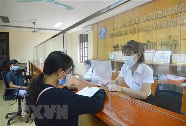 Cán bộ bảo hiểm xã hội hướng dẫn người dân kê khai đăng ký ứng dụng VssID. (Ảnh: Xuân Tư/TTXVN) Cán bộ bảo hiểm xã hội hướng dẫn người dân kê khai đăng ký ứng dụng VssID. (Ảnh: Xuân Tư/TTXVN)