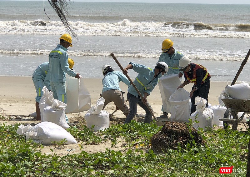 Công nhân công trình xúc cát để chèn mái công trình Công nhân công trình xúc cát để chèn mái công trình