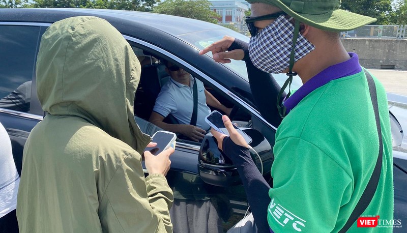 Nhân viên trạm thu phí hướng dẫn tài xế sử dụng dịch vụ thu phí không dừng qua cao tốc