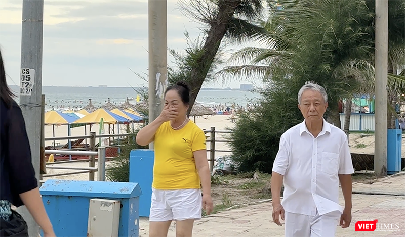 Người dân đi dạo trên bờ biển phải bịt mũi vì mùi khó chịu bốc lên từ vũng nước bẩn. vt_bien du lich 12.png
