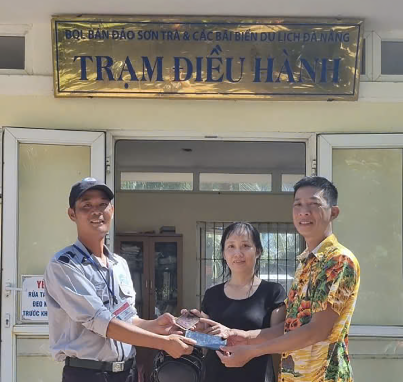 Anh Trinh trao lại tài sản thất lạc cho du khách sau khi tìm kiếm được. anh trao 2.png