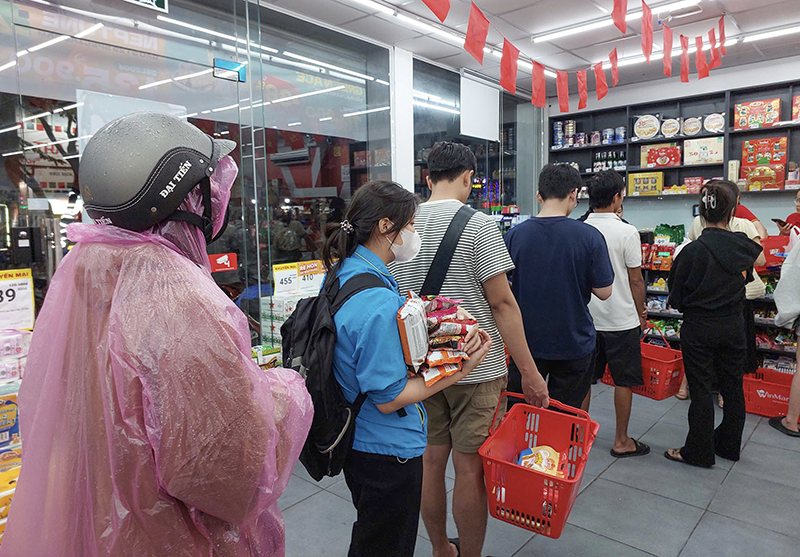 Cửa hàng Winmart với người mua xếp hàng dài chờ tính tiền mua hang 1.png
