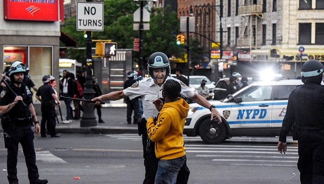 Cảnh sát yêu cầu một thiếu niên tuân thủ lệnh giới nghiêm sau 20h ở khu Bronx, New York (Ảnh: New York Times) Cảnh sát yêu cầu một thiếu niên tuân thủ lệnh giới nghiêm sau 20h ở khu Bronx, New York (Ảnh: New York Times)