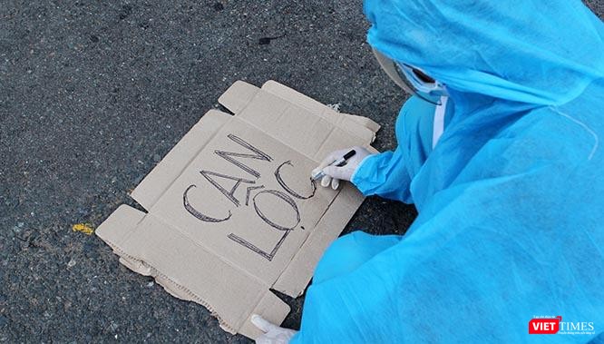 Viết vội tên huyện lên tấm bìa các tông ngay tại sân ga để tập hợp bà con, bởi thời gian gấp quá không kịp in ấn. Ảnh: GVT.