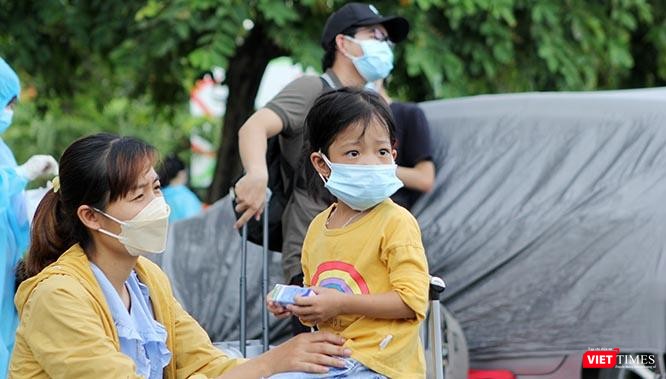 Ngơ ngác tại sân ga Sài Gòn khi thấy nườm nượp người giấu kín mình trong bộ đồ phòng hộ màu lam, cháu bé này khó có thể hình dung ra mình là hành khách nhí trên chuyến tàu đặc biệt trong đời di chuyển về quê giữa khi dịch Covid-19 đang bùng phát. Ảnh: GVT.