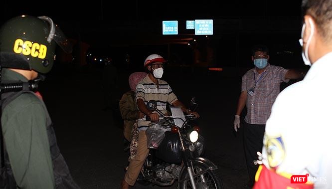 Lực lượng liên ngành nhắc nhở người dân không được ra đường sau 18h hằng ngày. Người đàn ông này giải thích đang đưa người nhà đến bệnh viện, nên được đồng ý cho đi. Ảnh: GVT.