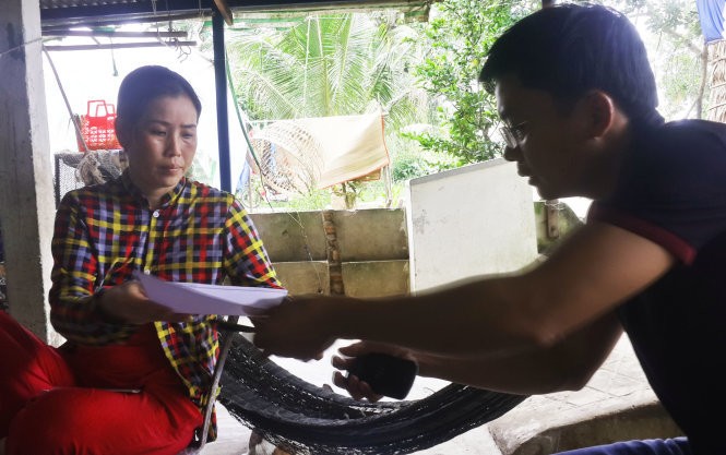 Chị Nguyễn Thị Kim Phương - vợ ngư dân Ngô Văn Sinh - ký đơn nhờ luật sư khởi kiện - Ảnh: K.Nam