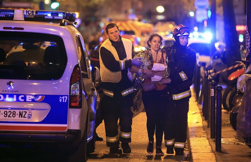 Nhân viên cứu hộ đang giúp một phụ nữ sau vụ xả súng ở nhà hát Bataclan, Paris đêm 13-11. Ảnh: Reuters. Nhân viên cứu hộ đang giúp một phụ nữ sau vụ xả súng ở nhà hát Bataclan, Paris đêm 13-11. Ảnh: Reuters.