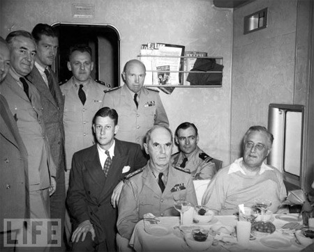 TT Franklin Delano Roosevelt (ngoài cùng bên phải) đón sinh nhật lần thứ 61 của ông trên máy bay từ Trinidad tới Miami năm 1943. Trên máy bay có các điệp viên Elmer Hipsley (người để ria, đang đứng) và Guy Spaman (mặc bộ vest tối màu đang ngồi). TT Franklin Delano Roosevelt (ngoài cùng bên phải) đón sinh nhật lần thứ 61 của ông trên máy bay từ Trinidad tới Miami năm 1943. Trên máy bay có các điệp viên Elmer Hipsley (người để ria, đang đứng) và Guy Spaman (mặc bộ vest tối màu đang ngồi).