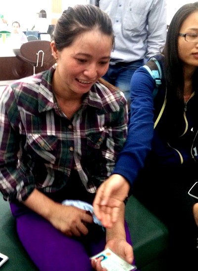 Chị Hồng chờ nhận tiền ở ngân hàng. Ảnh: Quốc Thắng