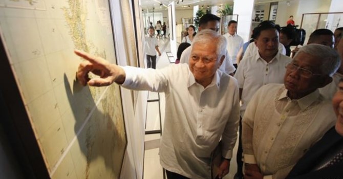 Ngoại trưởng Philippines Albert Del Rosario chỉ vào một bản đồ cổ bên cạnh Bộ trưởng Quốc phòng Voltaire Gazmin tại trường đại học Công giáo ở Manila.