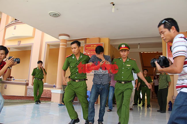 Trong khi cuộc họp báo đang diễn ra trên lầu, thì vào khoảng 14g, dưới tầng trệt, nghi can Nguyễn Hải Dương được công an dẫn giải đi nơi khác. - Ảnh: Bá Sơn