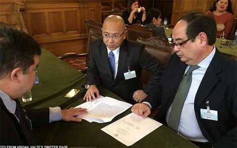 Cố vấn pháp luật của chính phủ Philippines Florin Hilbay đang thảo luận với các thành viên nhóm pháp lý của nước này tại phiên điều trần đầu tiên ở The Hague. (Ảnh: Abigail Valte)