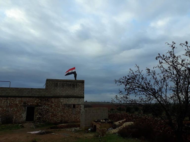 Quân đội Syria thượng cờ trên nóc nhà cao tầng của thành phố Manbij, Aleppo.