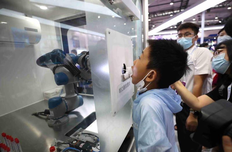 Một cậu bé trải nghiệm robot xét nghiệm Covid-19 trong Hội nghị Robot thế giới 2022 được tổ chức tại Bắc Kinh trong tháng 8. ZOU HONG /China Daily. Một cậu bé trải nghiệm robot xét nghiệm Covid-19 trong Hội nghị Robot thế giới 2022 được tổ chức tại Bắc Kinh trong tháng 8. ZOU HONG /China Daily.