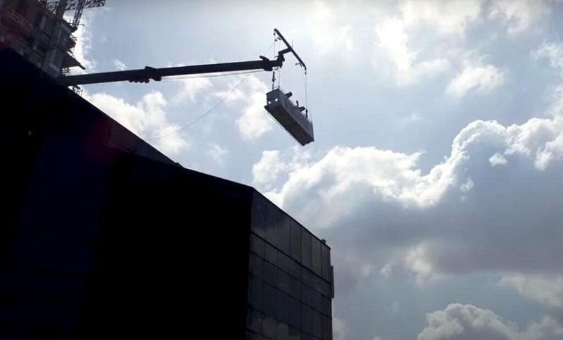 Các robot đi xuống từ bộ phận bảo trì tòa nhà - một thiết bị giống như cần cẩu - phổ biến cho tất cả các tòa nhà cao tầng. Ảnh Courtesy. Các robot đi xuống từ bộ phận bảo trì tòa nhà - một thiết bị giống như cần cẩu - phổ biến cho tất cả các tòa nhà cao tầng. Ảnh Courtesy.