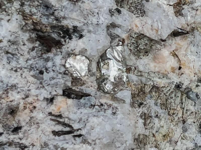 Tia sáng lấp lánh của kim loại liti màu trắng bạc trong đá ở khu mỏ Snow Lake Lithium. Ảnh New Atlas