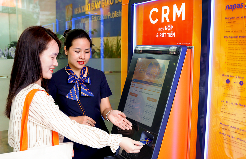 Giao dịch viên SHB hướng dẫn khách hàng sử dụng máy CRM anh 2. Nhân viên SHB hướng dẫn khách hàng sử dụng máy CRM.png