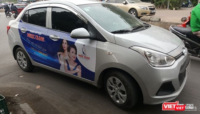 Taxi Uber, Grab “ngoài vòng pháp luật”, phớt lờ quy định niêm yết logo và số điện thoại? ảnh 1 Các taxi công nghệ đều không niêm yết số điện thoại của đơn vị kinh doanh ở hai bên thân xe hoặc hai bên cánh cửa xe. Ảnh: Một xe tuân thủ việc dán logo Grab tại phía trên, bên trái của kính chắn gió nhưng không niêm yết thông tin hãng.