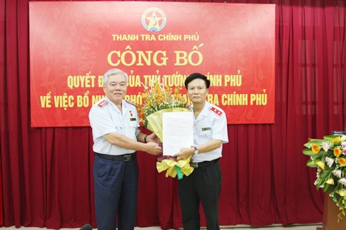 Ông Bùi Ngọc Lam nhận hoa và quyết định - Ảnh: TTCP