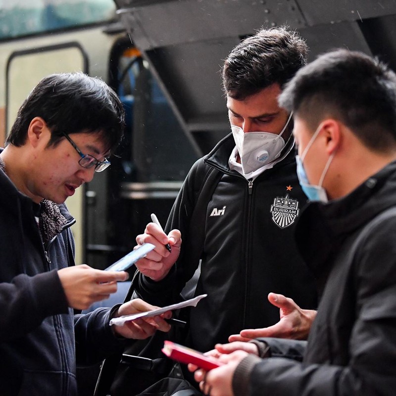 Các thành viên đội bóng Thái làm thủ tục ra sân. 