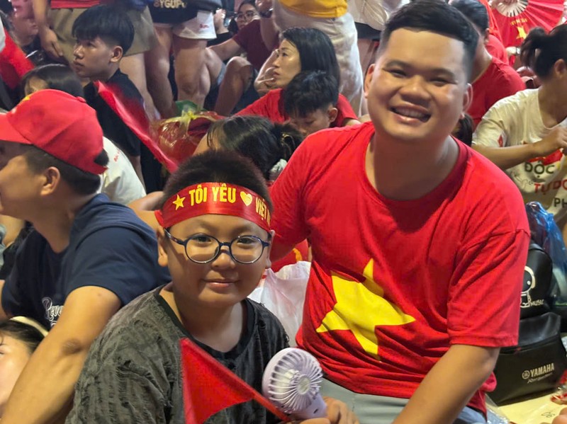 Bé trai này ở Thanh Xuân (Hà Nội), cùng người thân đi xem diễu binh từ 15h00 ngày 1/9. Mang theo băng rôn "Tôi yêu Việt Nam" và cờ tổ quốc, bé háo hức giờ phút diễu binh bắt đầu. A80_1 (14).jpg
