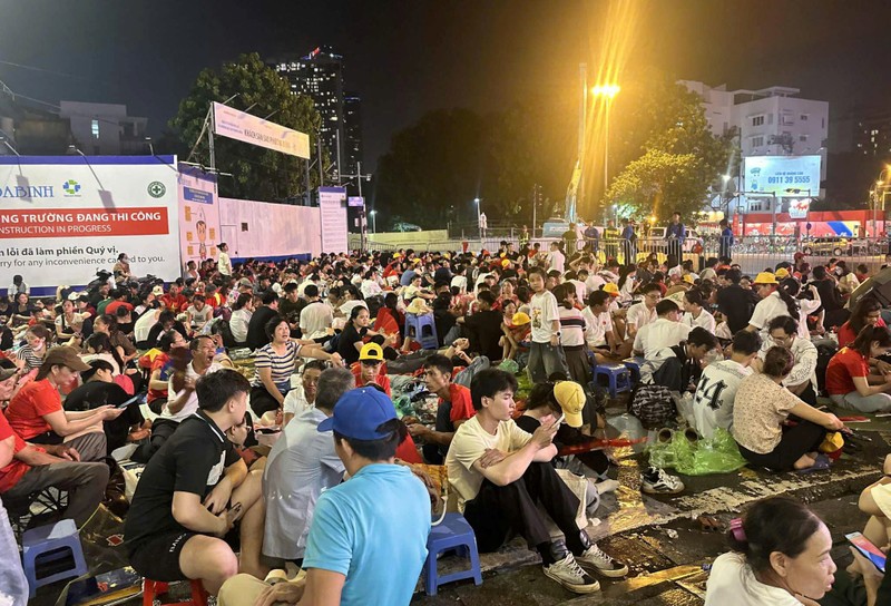 Ngã tư Núi Trúc - Kim Mã, nơi có màn hình Led, cũng có rất nhiều người tập trung để theo dõi. Người mang theo ghế, người trải chiếu, hoặc trải áo mưa lên vỉa hè. A80_1 (5).jpg