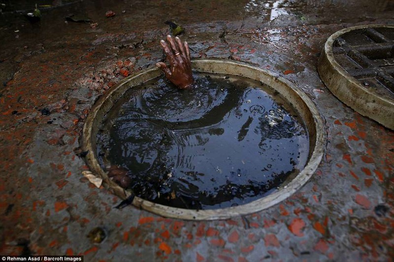 Họ chiến đấu với bùn đất được tạo ra trong các đường ống cống chật chội