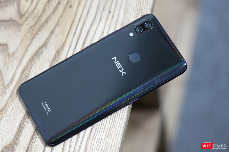 Mặt lưng của Vivo Nex A được làm từ kính, khá bám vân tay. Chúng tôi đã thử dùng khăn lau nhưng vẫn không hết dầu tay. Có lẽ biết vậy nên Vivo đã tặng cho người dùng một ốp lưng "đồng màu đồng chất" trong hộp phụ kiện. Chúng ta có thể thấy sự hiện diện của cụm camera kép và đặc biệt là máy quét vân tay. Ở phiên bản Vivo Nex S cao cấp hơn thì máy quét vân tay được nhúng thẳng vào màn hình, còn bản Nex A này thì nằm ở mặt lưng. Mặt lưng của Vivo Nex A được làm từ kính, khá bám vân tay. Chúng tôi đã thử dùng khăn lau nhưng vẫn không hết dầu tay. Có lẽ biết vậy nên Vivo đã tặng cho người dùng một ốp lưng "đồng màu đồng chất" trong hộp phụ kiện. Chúng ta có thể thấy sự hiện diện của cụm camera kép và đặc biệt là máy quét vân tay. Ở phiên bản Vivo Nex S cao cấp hơn thì máy quét vân tay được nhúng thẳng vào màn hình, còn bản Nex A này thì nằm ở mặt lưng.