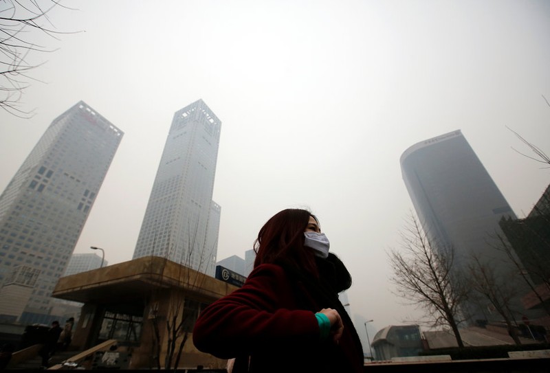 Một người phụ nữ đi qua màn khói bụi ở Bắc Kinh (ảnh: Reuters) Một người phụ nữ đi qua màn khói bụi ở Bắc Kinh (ảnh: Reuters)
